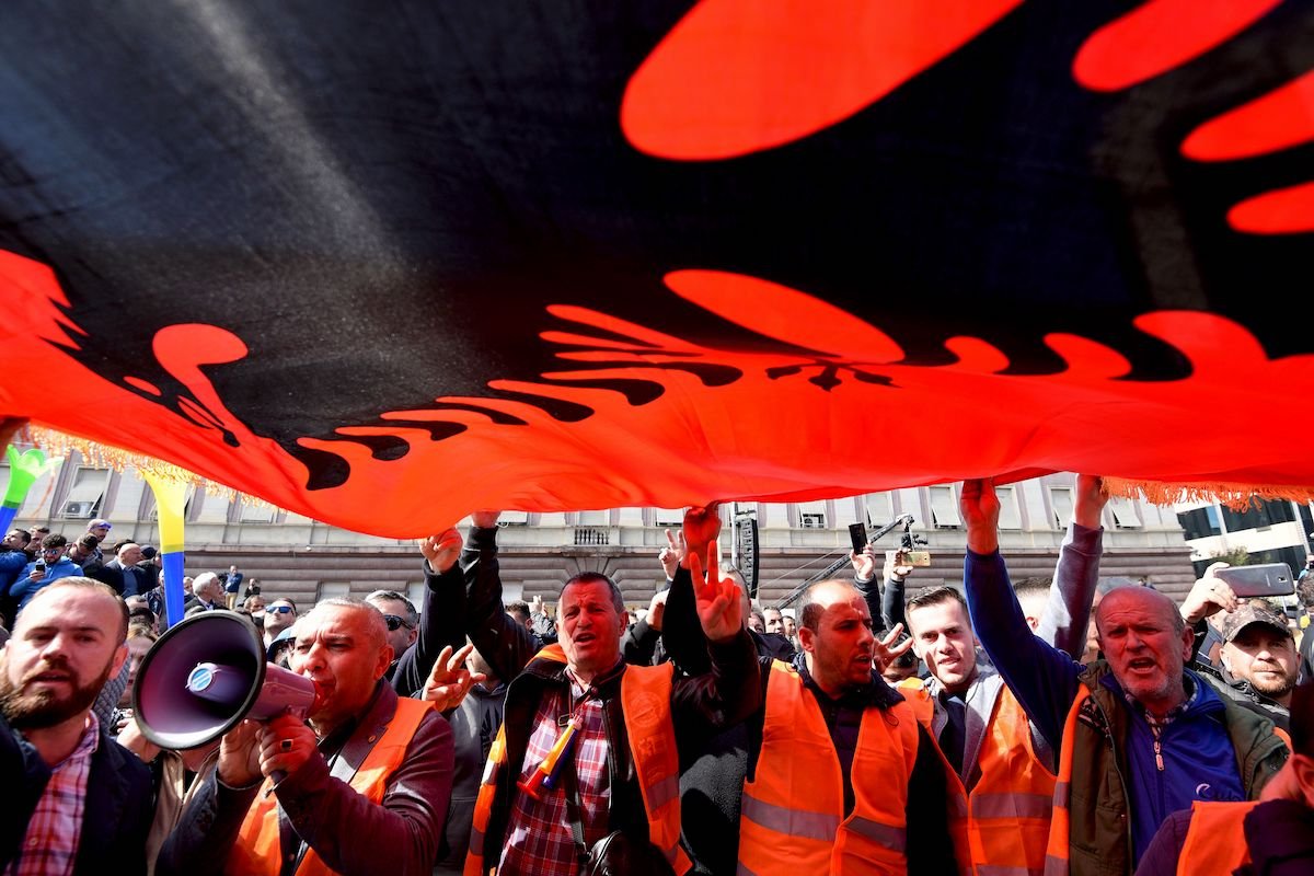 Protesters in Tirana outside the Parliament hold a giant Albanian national flag during a demonstration held to demand the resignation of the Albanian Prime Minister in March, 2019.